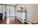Inviting foyer featuring hardwood floors, white front door with sidelight window and stylish distressed sideboard with mirror at 7658 S Country Club Pkwy, Aurora, CO 80016