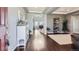 Welcoming foyer showcasing hardwood floors, tray ceilings, decorative shelving, and an arched entryway to living area at 7658 S Country Club Pkwy, Aurora, CO 80016