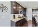 Stylish kitchen featuring dark wood cabinets, stainless steel appliances, and granite countertops at 7658 S Country Club Pkwy, Aurora, CO 80016