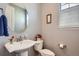 Updated powder room featuring a pedestal sink, toilet, and decorative accents at 7658 S Country Club Pkwy, Aurora, CO 80016