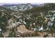 Aerial view of the hillside community surrounded by wooded areas and snow-capped mountains at 21609 Clarence Ln, Golden, CO 80401