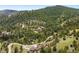 Remote wooded acreage with a sprawling home featuring a long driveway and beautifully landscaped grounds at 21609 Clarence Ln, Golden, CO 80401