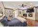 Well-lit bedroom with hardwood floors, a cozy fireplace, and a flat-screen television at 21609 Clarence Ln, Golden, CO 80401