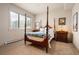 Bright bedroom with a four-poster bed, neutral walls, and mountain views from the window at 21609 Clarence Ln, Golden, CO 80401