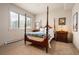 Traditional bedroom with four-poster bed, bedside tables, and natural light from a large window at 21609 Clarence Ln, Golden, CO 80401