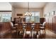 Formal dining room with natural light, beautiful wood table set for eight, and wood trim at 21609 Clarence Ln, Golden, CO 80401