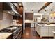 Gourmet kitchen with stainless steel appliances, center island, and hardwood floors overlooking another living space at 21609 Clarence Ln, Golden, CO 80401