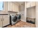 Bright laundry room with front load washer and dryer, white cabinets, tiled floors, and a dog wash at 21609 Clarence Ln, Golden, CO 80401