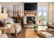 Cozy living room with stone fireplace, hardwood floors, and scenic views through the windows at 21609 Clarence Ln, Golden, CO 80401