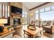 Living room with a stone fireplace, hardwood floors, and expansive windows showing nature at 21609 Clarence Ln, Golden, CO 80401