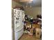 Cluttered kitchen with white appliances, wooden cabinetry, and tile flooring, needs a good cleaning at 10706 Owens St, Broomfield, CO 80021