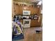 Cluttered kitchen featuring wooden cabinetry, white appliances, and tile floors, presenting renovation opportunity at 10706 Owens St, Broomfield, CO 80021