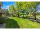 Manicured backyard with a lush green lawn and mature trees providing shade and privacy at 9278 E Aspen Hill Pl, Lone Tree, CO 80124
