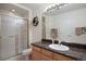 Bright bathroom featuring granite countertops, wood cabinets and a glass shower at 9278 E Aspen Hill Pl, Lone Tree, CO 80124