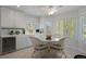 Sunlit breakfast nook with white wicker furniture and views through shuttered windows at 9278 E Aspen Hill Pl, Lone Tree, CO 80124