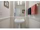 Neat powder room featuring a pedestal sink, decorative mirror, and neutral color scheme at 9278 E Aspen Hill Pl, Lone Tree, CO 80124