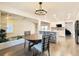 Bright dining room with dark wood floors, a modern chandelier and kitchen views at 5126 S Kenton Way, Englewood, CO 80111