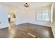 Empty room featuring hardwood floors, shuttered window, and a view of the kitchen at 5126 S Kenton Way, Englewood, CO 80111