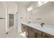Bathroom features a double vanity with sleek countertops, modern lighting, and a glass shower at 5936 N Lisbon St, Aurora, CO 80019