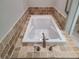A tiled in soaking tub with modern faucet and tiled surround at 656 County Road 72, Bailey, CO 80421