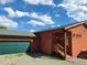 Charming wood cabin-style home with a green roof and matching garage door beneath a bright, cloudy sky at 656 County Road 72, Bailey, CO 80421