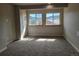 Bright living room with plush carpet, neutral walls, and two windows showcasing mountain views at 656 County Road 72, Bailey, CO 80421