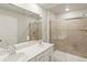 Modern bathroom featuring double sinks, quartz countertop, and glass-enclosed shower with attractive stone-look tile at 255 Mayfly Ln, Berthoud, CO 80513