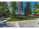 Large private backyard offering manicured turf, concrete patio and mature shade trees at 5672 S Hanover Way, Greenwood Village, CO 80111