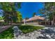 Spacious backyard featuring lush turf grass, concrete walkway, and established trees at 5672 S Hanover Way, Greenwood Village, CO 80111