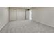 A carpeted bedroom with an open door, closet and neutral colored walls at 5672 S Hanover Way, Greenwood Village, CO 80111