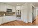 Bright kitchen features white cabinets, stainless steel appliances, granite countertops, and hardwood floors at 5672 S Hanover Way, Greenwood Village, CO 80111