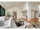 Bright living room with hardwood floors, a wet bar, and a vaulted ceiling with a glimpse of the dining room at 5672 S Hanover Way, Greenwood Village, CO 80111