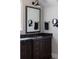 Bathroom with dark vanity, marble countertop, and gold fixtures at 9356 Cherrywood Trl, Littleton, CO 80127