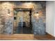 Glass-walled home gym with stone accents and equipment at 9356 Cherrywood Trl, Littleton, CO 80127