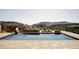 Luxury pool featuring built-in slide and mountain views, surrounded by stone decking and lounge chairs at 9356 Cherrywood Trl, Littleton, CO 80127