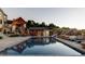Resort-style pool area features slide, outdoor kitchen, and seating, perfect for entertaining at 9356 Cherrywood Trl, Littleton, CO 80127