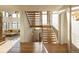 Grand wooden staircase with wrought iron railing and bright natural light at 9356 Cherrywood Trl, Littleton, CO 80127