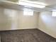 A cozy carpeted basement with natural light from a window, offering a versatile space at 3798 S Grant St, Englewood, CO 80113
