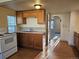 Functional kitchen with wooden cabinets, light countertops, and arched doorway to the living area at 3798 S Grant St, Englewood, CO 80113