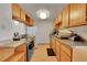 Functional kitchen with oak cabinets, modern appliances, and laminate floors for easy cleaning at 9925 W 20Th Ave # 17, Lakewood, CO 80215
