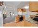 Open kitchen layout with wooden cabinets, modern appliances, and a view into the living room at 9925 W 20Th Ave # 17, Lakewood, CO 80215