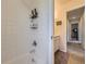 Bathroom featuring a white tiled shower and a hallway with natural light at 3508 E 140Th Pl, Thornton, CO 80602