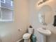 Powder room features pedestal sink, round mirror, and natural light at 3508 E 140Th Pl, Thornton, CO 80602