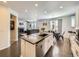 Open-concept kitchen and living area with granite island, hardwood floors, and fireplace at 3508 E 140Th Pl, Thornton, CO 80602