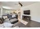 Open-concept living room with hardwood floors, ceiling fan, and view into the modern kitchen at 3508 E 140Th Pl, Thornton, CO 80602