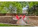 Beautiful backyard with mature trees and a charming fire pit area with red Adirondack chairs at 1285 Aberdeen Dr, Broomfield, CO 80020
