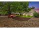 Expansive backyard featuring mature trees, red adirondack chairs, and a gravel-lined firepit, perfect for outdoor relaxation at 1285 Aberdeen Dr, Broomfield, CO 80020