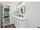Modern bathroom featuring dual sinks, decorative mirrors, and wood flooring at 1285 Aberdeen Dr, Broomfield, CO 80020