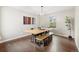 Inviting dining room featuring a long wooden table with a bench, modern art, and hardwood floors at 1285 Aberdeen Dr, Broomfield, CO 80020