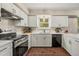 Updated kitchen with white cabinetry, modern appliances, and a stylish rug, blending functionality with style at 1285 Aberdeen Dr, Broomfield, CO 80020